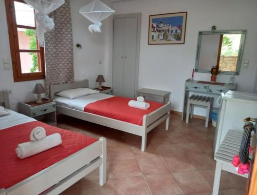 een slaapkamer met 2 bedden, een wastafel en een spiegel bij Pension Patelo in Pitsidia