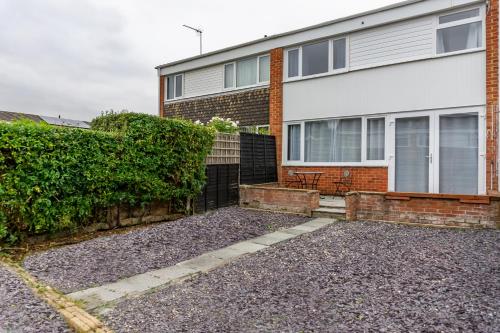 a house with a fence and a hedge at Inspiration by Olauda SA - 3 Bed House with Free Parking in Swindon