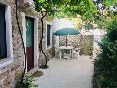 a patio with a table and an umbrella at Kelu e Terra - Locazione Turistica - IUN Q0467 in Onifai