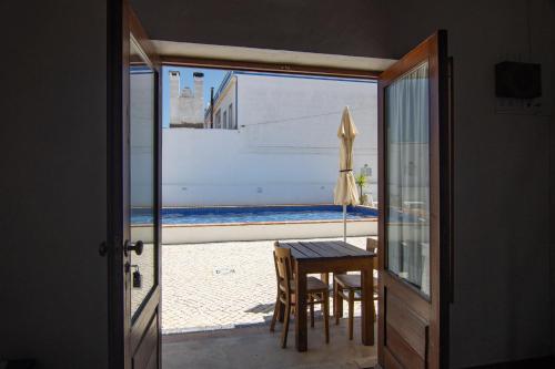 a view of a table and an umbrella from a door at Carrapateiramar Guest House in Carrapateira