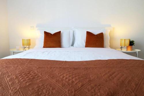 1 dormitorio con 1 cama grande con almohadas rojas en Albufeira Central Apartment, 10 mins walk to beach en Albufeira