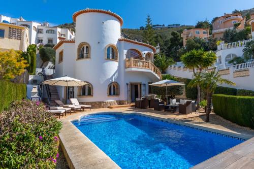 eine Villa mit einem Pool und einem Haus in der Unterkunft Casa Sueños in Benitatxell