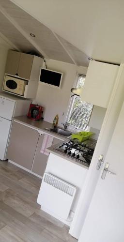 La cuisine est équipée d'appareils électroménagers blancs et d'un four avec plaques de cuisson. dans l'établissement Ferme de Chiuni, à Cargèse