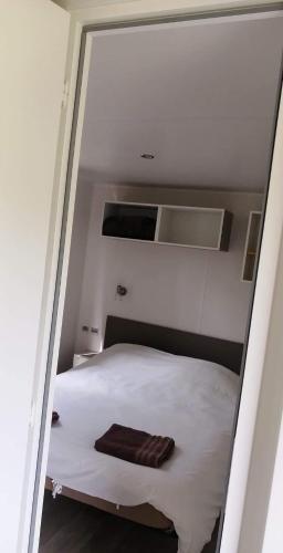 une chambre avec un lit blanc avec deux serviettes dessus dans l'établissement Ferme de Chiuni, à Cargèse