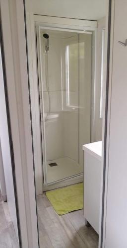 La salle de bains est pourvue d'une douche et d'un tapis jaune. dans l'établissement Ferme de Chiuni, à Cargèse