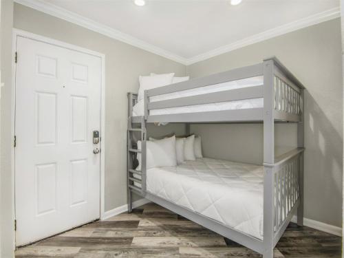 ガルベストンにあるSeascape 2110 Condoの白い二段ベッドが備わるドア付きの客室です。