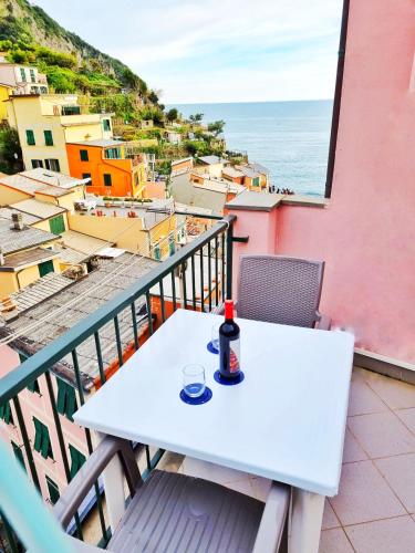 a white table on a balcony with a view of the ocean at Good vibes penthouse Ca Lidia 5terreparco in Riomaggiore