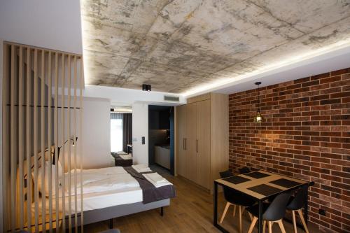 a room with a bed and a brick wall at Apartamenty Posejdon in Łazy