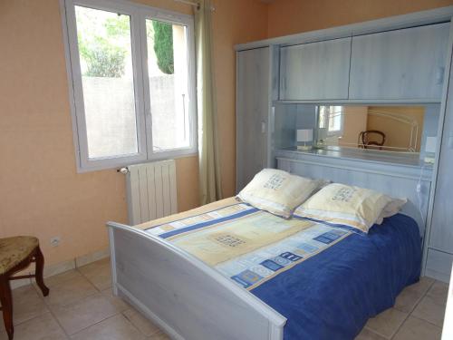 um quarto com uma cama com lençóis azuis e uma janela em La Journale em Coux