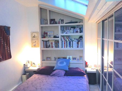 une chambre avec un lit avec un oreiller bleu dessus dans l'établissement Modern Design Loft Apartment, Steps to Notre Dame, à Paris