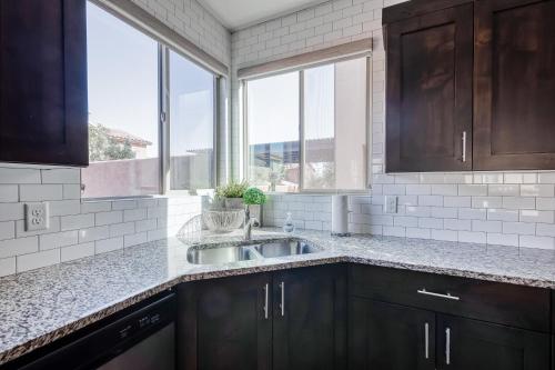 eine Küche mit einem Waschbecken und einigen Fenstern in der Unterkunft Desert Escape Paradise Village 93 in Santa Clara