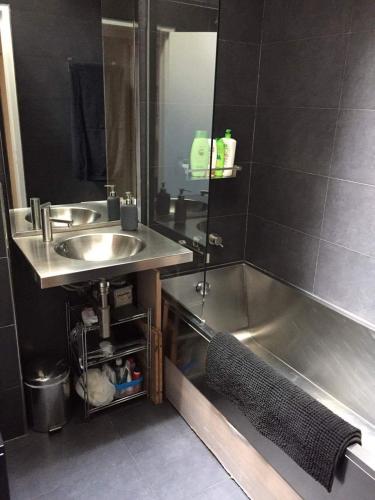 La salle de bains est pourvue d'un lavabo et d'une baignoire à côté d'un lavabo. dans l'établissement Modern Design Loft Apartment, Steps to Notre Dame, à Paris