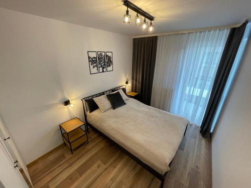 ein Schlafzimmer mit einem großen Bett und einem Fenster in der Unterkunft NEWPORT Industrial Apartment in Warschau
