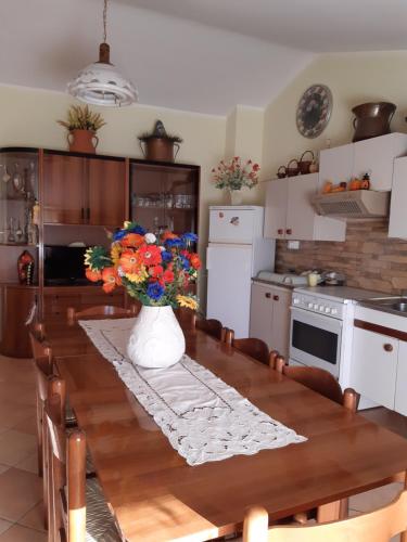 a kitchen with a table with a vase of flowers on it at IL GIRASOLE in Castelvecchio Calvisio