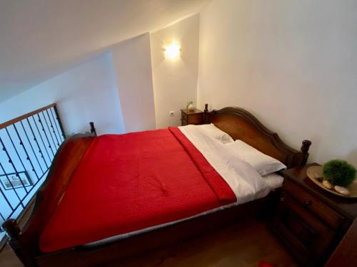 a bedroom with a bed with a red blanket at Apartment Blue in Sveti Stefan