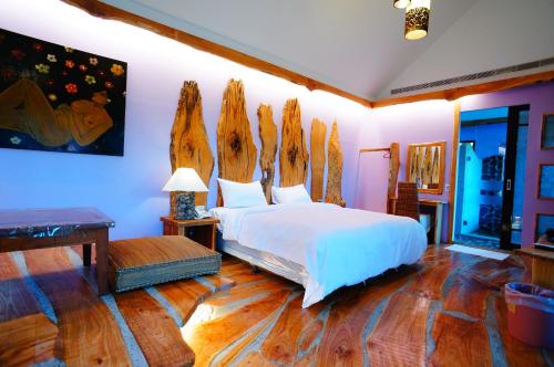 恆春的住宿－墾丁海芋 獨棟泳池Villa，一间卧室配有一张带木头床头板的床