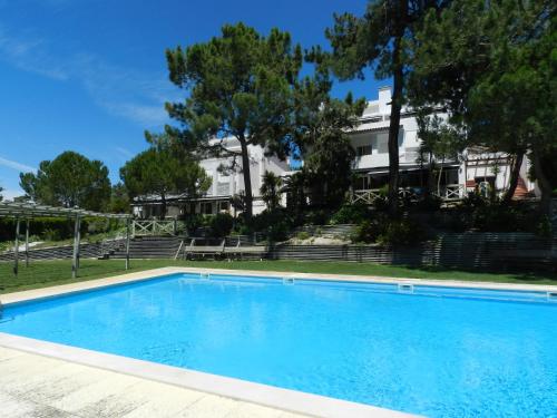 a swimming pool in front of a house at Ananda Troia in Troia