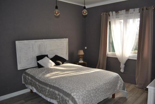 a bedroom with a large bed and a window at gîtes aux portes des Cévennes in Saint-Christol-lès-Alès