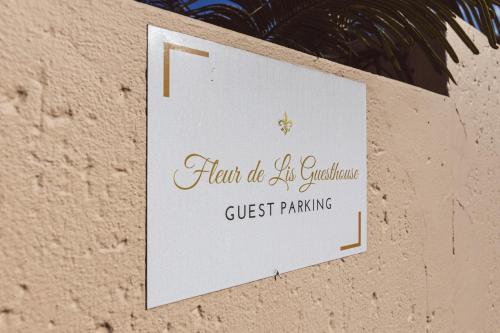 a sign on a wall that reads guest parking at Fleur de Lis Guesthouse in Krugersdorp