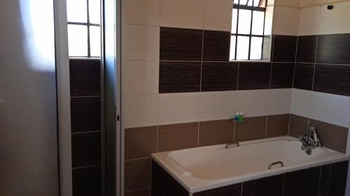 a bathroom with a bath tub and a window at dreamplace Gigiri in Nairobi