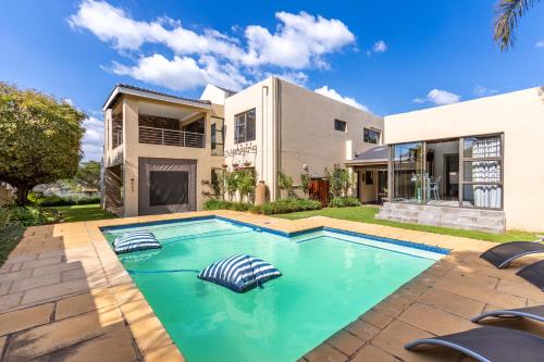 una piscina frente a una casa en Fleur de Lis Guesthouse, en Krugersdorp