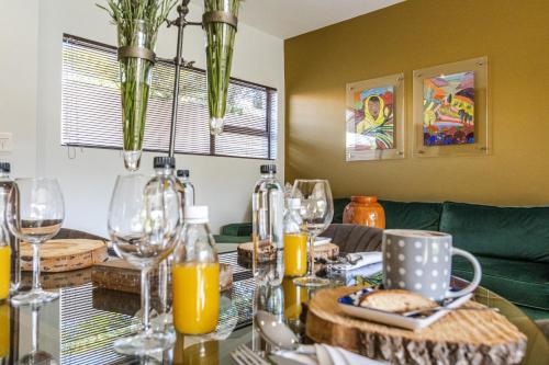 a dining room table with wine glasses and orange juice at Fleur de Lis Guesthouse in Krugersdorp
