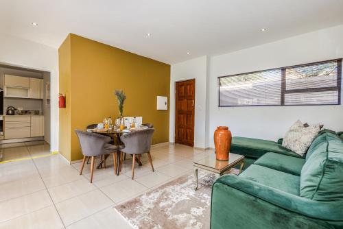 a living room with a green couch and a table at Fleur de Lis Guesthouse in Krugersdorp
