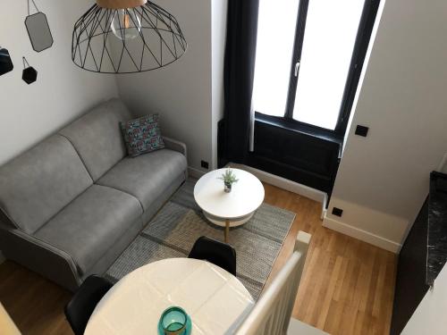 uma sala de estar com um sofá e uma mesa em DUPLEX COSY HYPER CENTRE CHOLET em Cholet