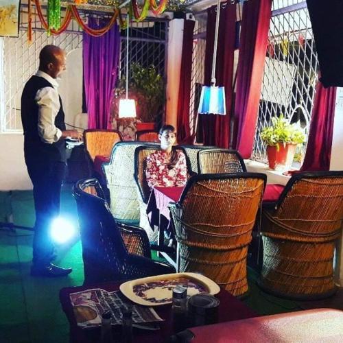 a man standing next to a woman in a restaurant at IL Padrino hotel in Pushkar