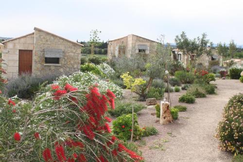 a garden with flowers and a building in the background at Agroturisme Es Racó De Maria in Maria de la Salut