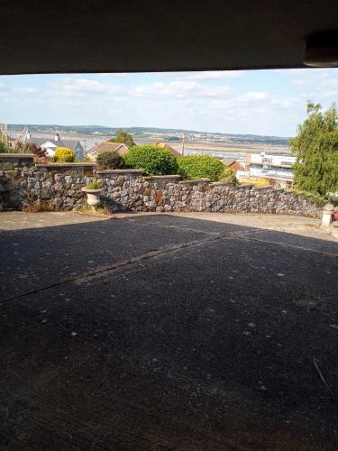an empty street next to a stone wall at Violet Mays Haven in Starcross