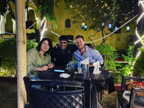 a group of three people sitting at a table at IL Padrino hotel in Pushkar