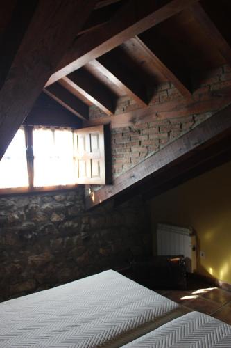 a bedroom with a bed and a brick wall at La Venta de Quijas in Quijas