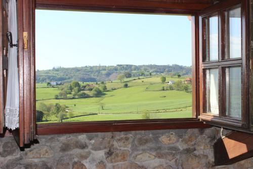 une fenêtre avec vue sur un champ verdoyant dans l'établissement La Venta de Quijas, à Quijas