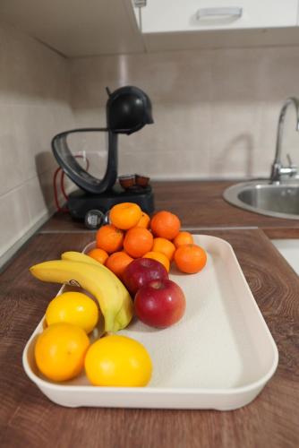 a white plate of fruit on a table at Apartments Manitovac M in Nikšić