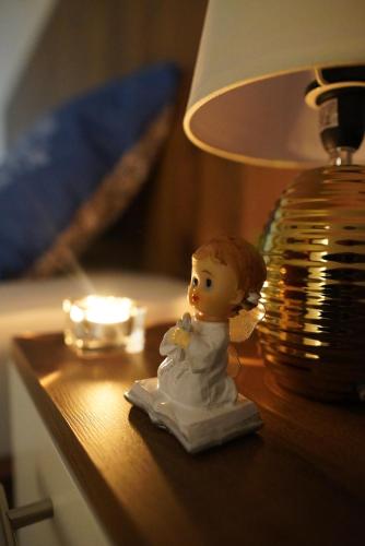 a small figurine sitting on a table next to a lamp at Apartments Manitovac M in Nikšić