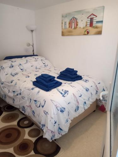 a bedroom with a bed with blue towels on it at Violet Mays Haven in Starcross