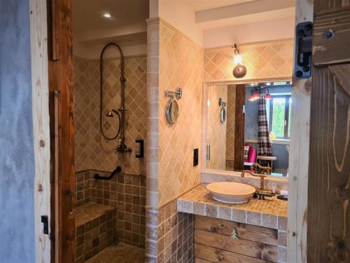 a bathroom with a sink and a shower at Domaine du Haut Jardin Hôtel & Chalets Spa Privé in Rehaupal