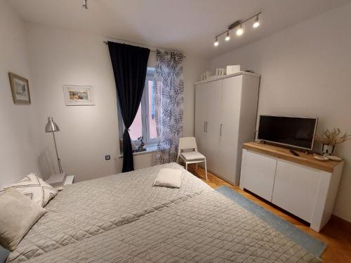 1 dormitorio con 1 cama grande y TV en Apartment Yes en Zadar