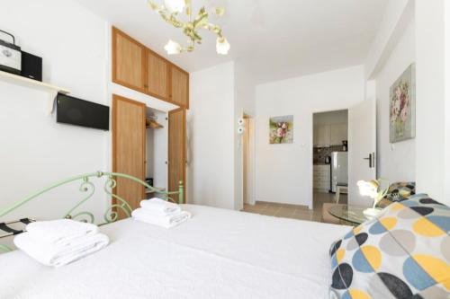 a bedroom with a large white bed and a kitchen at Pension Moschoula in Platis Gialos