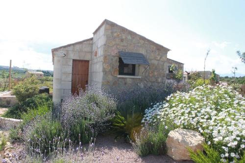 a small stone building in a garden with flowers at Agroturisme Es Racó De Maria in Maria de la Salut