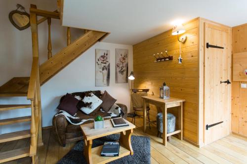a living room with a staircase and a couch at Domaine du Haut Jardin Hôtel & Chalets Spa Privé in Rehaupal
