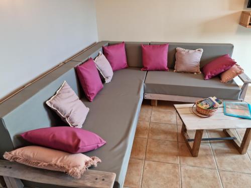 a couch with many pillows on it in a room at L'ortu di Quaprice in Figari