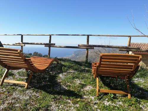 two wooden chairs sitting on top of a hill at Agricoltura Rascio in San Mauro Cilento