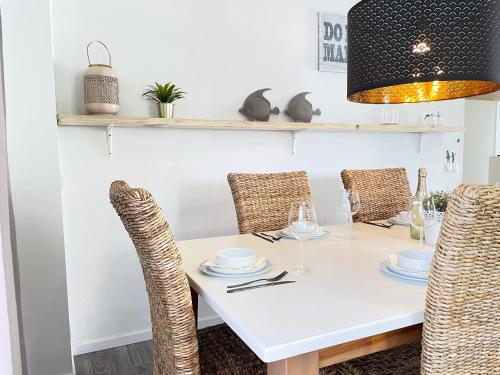 a dining room with a white table and chairs at Fewo MAIN URLAUB an der Mainschleife in Obereisenheim