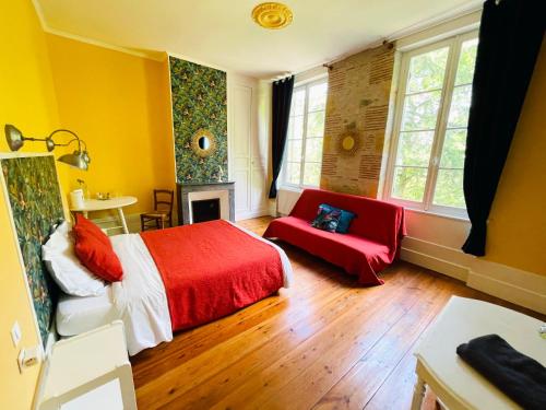Aiguillon的住宿－Le Baraillot, Chambres et repas d'hôtes, soirée étape，一间卧室配有红色的床和红色的沙发