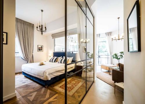 a bedroom with a bed and a large mirror at VELLER Mapu in Tel Aviv