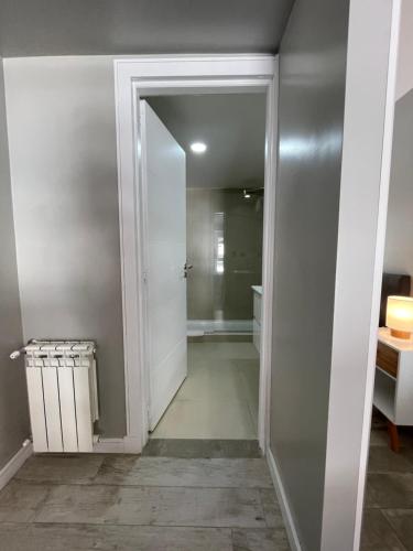 un pasillo con una puerta que conduce a un baño en Acqua Apartments Bariloche, en San Carlos de Bariloche