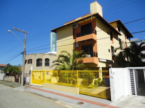 a yellow house with a yellow fence in front of it at Regina del mare apartamento de 02 dormitorios para até 06 pessoas a 50 mts da praia in Florianópolis