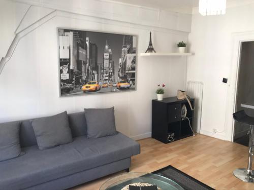 un salon avec un canapé et un tableau au mur dans l'établissement Rosiers, à Paris